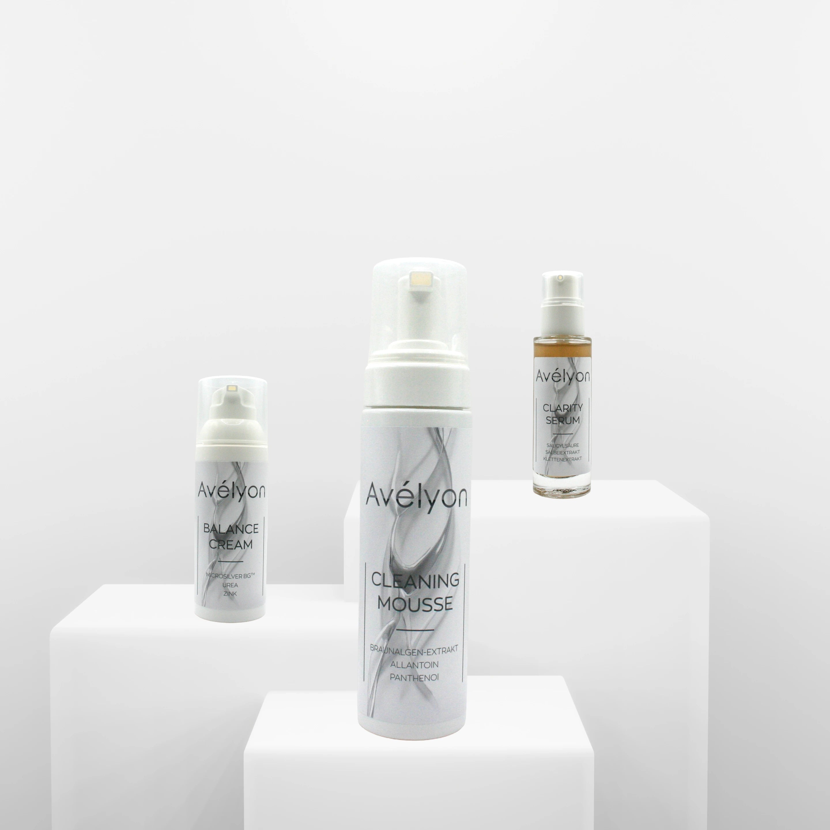 Avélyon 3-Step Set mit Clean Mousse, Clarity Serum und Balance Cream auf weißen Podesten