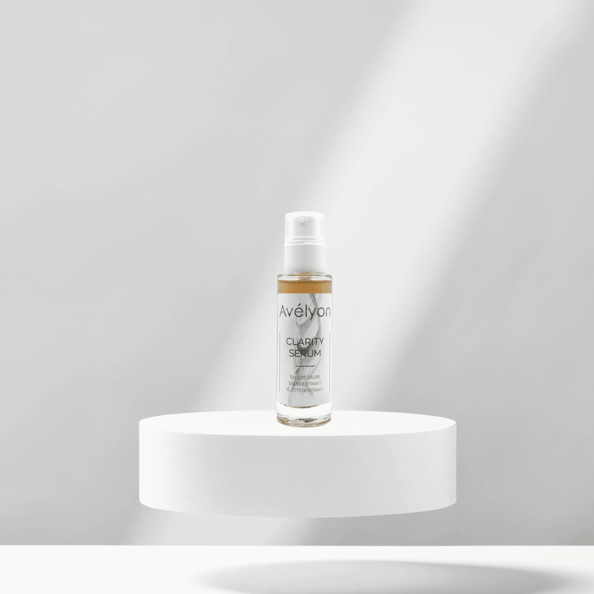 Avélyon Clarity Serum auf weißem rundem Podest vor hellem Hintergrund